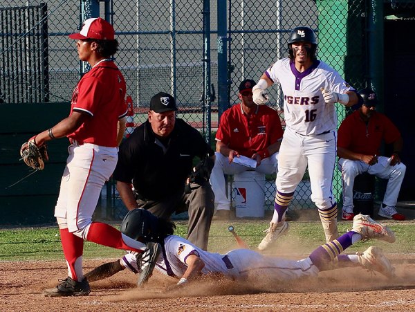 Lemoore's Gavin Kyker starts the celebration as Dominick Najar slides into home to win the game against Hanford.